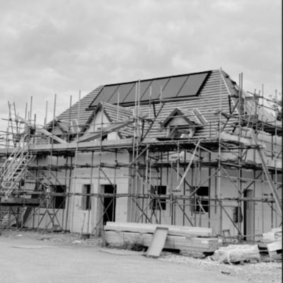 Property under construction with solar panels and scaffolding
